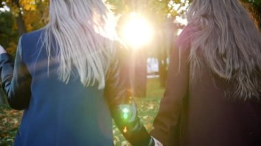 Mutlu kız açık havada eğleniyor. Kız çayır üzerinde yürümek. El ele ve bir alanda yürüyüş iki kız