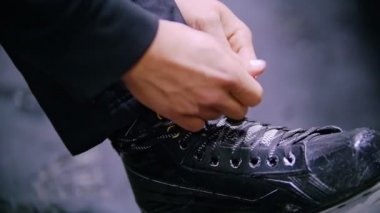 Eller arka planı koyu zemin hokey paten ayakkabı bağcığı bağla