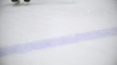 Hokey oyuncusu geriye doğru sürmek ve saçılma buz parçacıkları bir hokey alanının buza yavaşlar