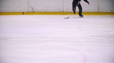 Hokey oyuncusu yol açar pak ve buz hokeyi maçında çalışıyor. Kameranın doğru çalışan