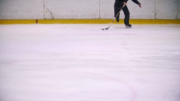 Hokejista vede PUK a běží na ledě během hokejového zápasu. Běh směrem k fotoaparátu