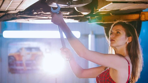 Sexy dziewczyna mechanik naprawia auto z klucza. Portret strzał — Zdjęcie stockowe