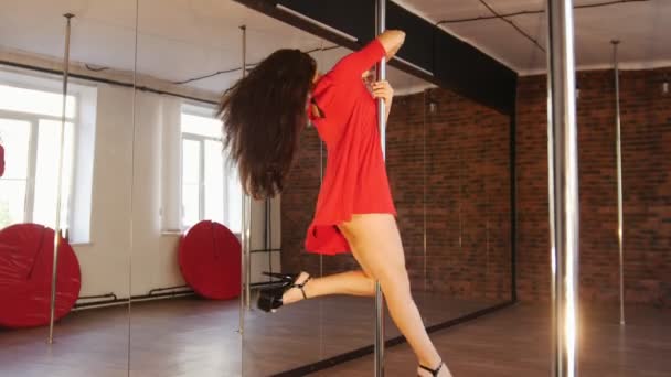 Ragazza sexy in abito rosso pole dance. Girando intorno al palo — Video Stock