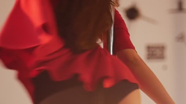 Сексуальная девушка в красном платье с шестом. Кружится вокруг шеста. Медленное движение — стоковое видео