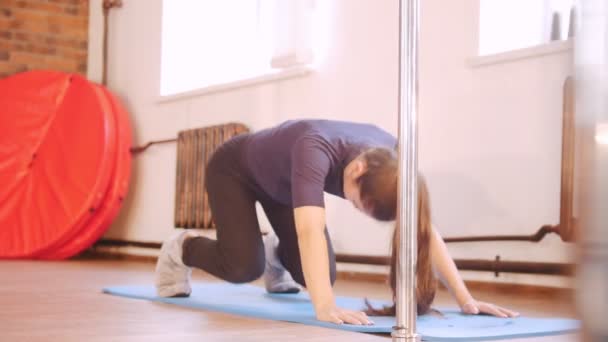 Девушка разогревается и делает упражнения на ковриках — стоковое видео
