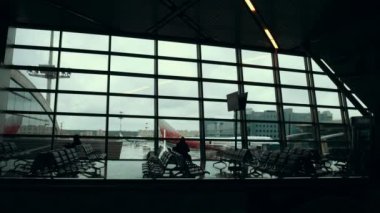 Havaalanı terminal, insan siluetleri tarafından bir cam pencere karşı yürüyüş.