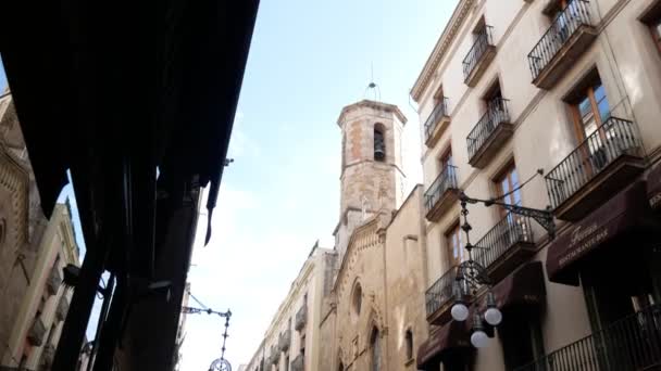 Barcelona, Spanje - September 2018: Gotische kerk klokkentoren en muren tegen blauwe hemel uitzicht vanaf kleine straat. — Stockvideo