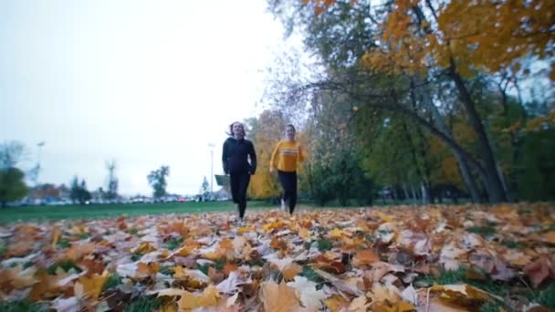 Jonge passen vrouwen loopt over de camera in de herfst park. — Stockvideo