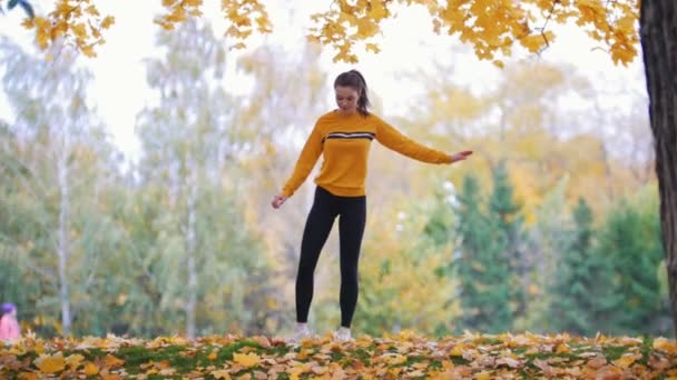 Meisje doet acrobatische staan. Turnster voor training. Herfst — Stockvideo