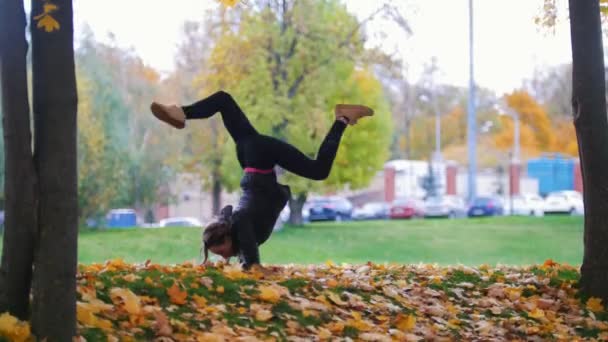 Rapariga a fazer acrobacias nas mãos. Treinamento de ginasta no parque — Vídeo de Stock