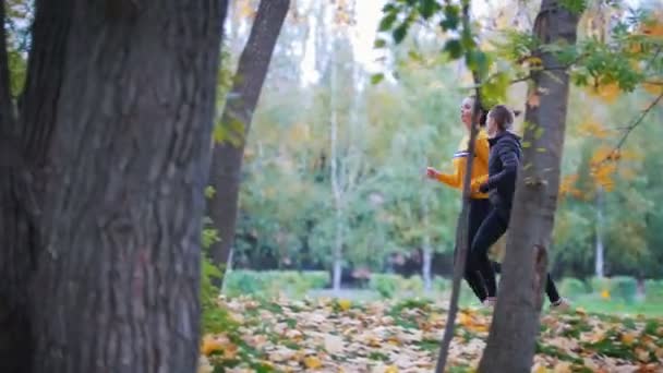 Chicas activas corriendo en el parque de otoño — Vídeos de Stock