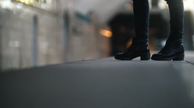 Metro tren için bekleyen genç kadın. Sadece bacaklar gösteren.