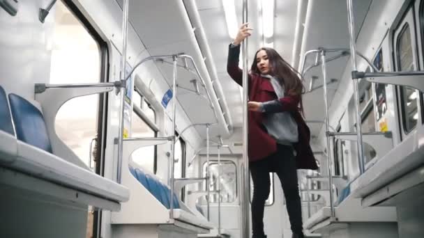 Młoda kobieta tańczy w pociągu metra. Taniec na rurze. Latające włosy — Wideo stockowe