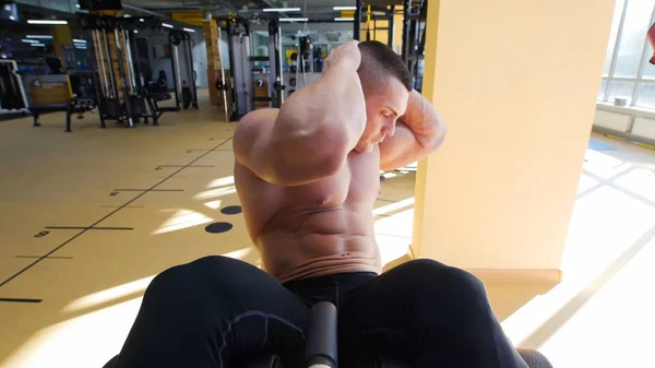 Spor salonunda bir bankta egzersizi vücut geliştirmeci çıplak gövde ile taytlı gerçekleştirir — Stok fotoğraf