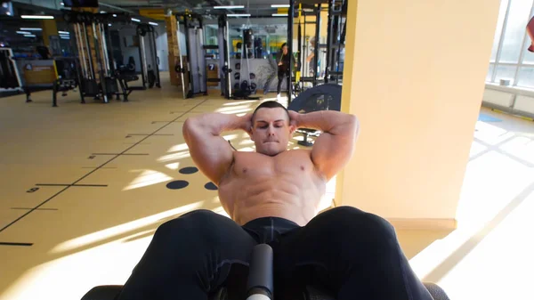 Spor salonunda bir bankta egzersizi çıplak gövde ile vücut geliştirmeci gerçekleştirir — Stok fotoğraf