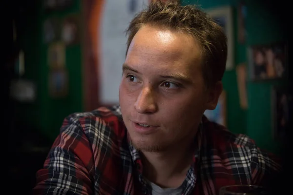 Knappe jonge man aan de bar zitten teller — Stockfoto