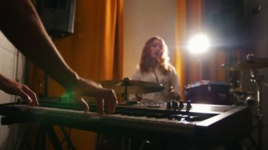 Tekrarlama. Davul ve bir adam klavyelerde oynayan kız. Odak elinde