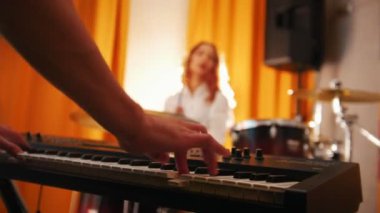 Tekrarlama. Davul ve klavye bir adamı oynayan kız. Odak elinde