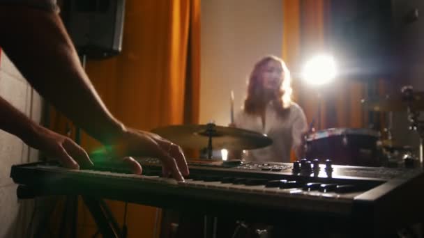 Ripetizione. Una batterista e un ragazzo alle tastiere. Mani a fuoco — Video Stock