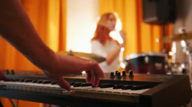 Tekrarlama. Davul ve klavye bir adamı oynayan kız. Elinden davul için odak