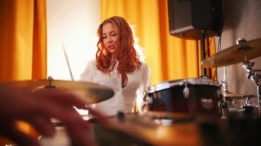 Tekrarlama. Kız davulcu ve klavye üzerinde bir adam. Bateri eller için odak