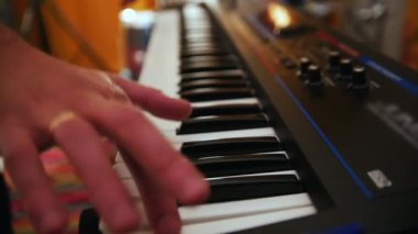 Tekrarlama. Adam klavye üzerinde çalış, kız backgrond bateri çalıyor. Backlights. Eller üzerinde odaklanın. ağır çekim