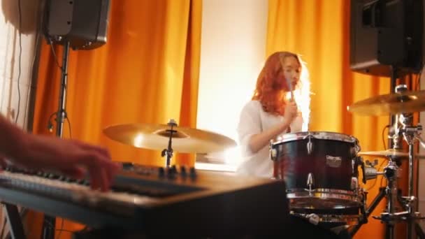 Herhaling. Meisje spelen op drums en een kerel op keyboards. Handen in focus. Schuifregelaar schot — Stockvideo
