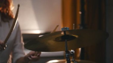 Tekrarlama. Kızıl saçlı kız davul plakaları üzerinde çalış. Portre. Backlights.