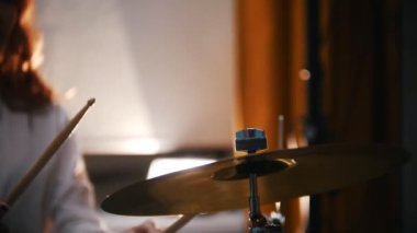 Tekrarlama. Kızıl saçlı kız davul plakaları üzerinde çalış. yavaş motiom titreşim. Backlights.