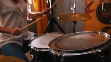 Tekrarlama. Kızıl saçlı kız üzerinde bateri çalıyor. Studiolights. Davulda odaklanmak