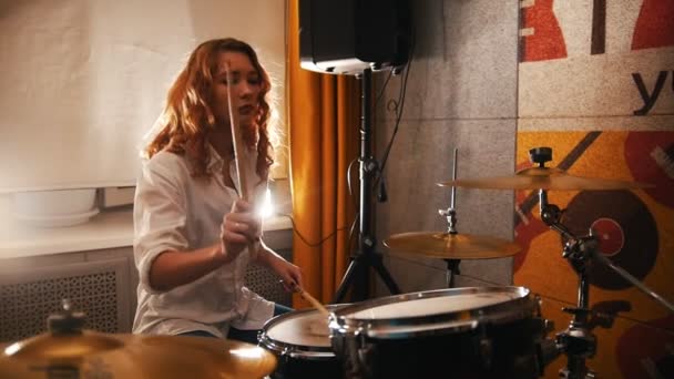 Herhaling. Roodharige meisje speelt op drums. Studiolights — Stockvideo