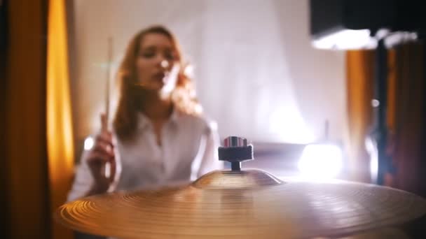 Herhaling. Roodharige meisje speelt op drums. Slow-motion. Focus op plaat — Stockvideo