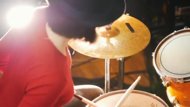 Repetición. Chica de sombrero negro toca la batería. Iluminación brillante — Vídeos de Stock