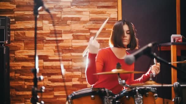 Επανάληψη. Κορίτσι με το κόκκινο πουλόβερ με πάθος παίζει ντραμς — Αρχείο Βίντεο