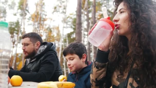 Mama Tata Dziecko Siedzi Pobliżu Siebie Zewnątrz Lesie Przy Stole — Wideo stockowe