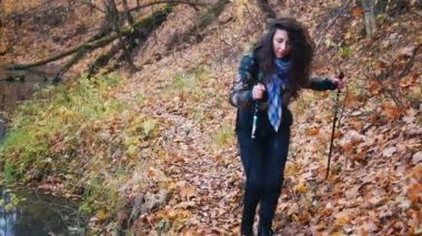 Genç kadın ormandaki İskandinav yolda kıvırcık saçlı. Kadın creek alır.