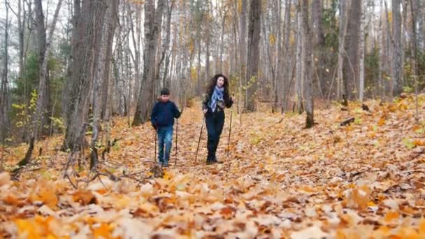 Jeune femme aux cheveux bouclés et un garçon en promenade scandinave. Saison d'automne . — Video