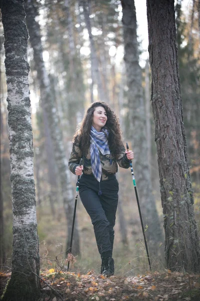 Portrét šťastná žena s kudrnatými vlasy podzim. Radostné a úsměvů mladá žena baví v parku slunečný podzim. Šplhání do kopce — Stock fotografie