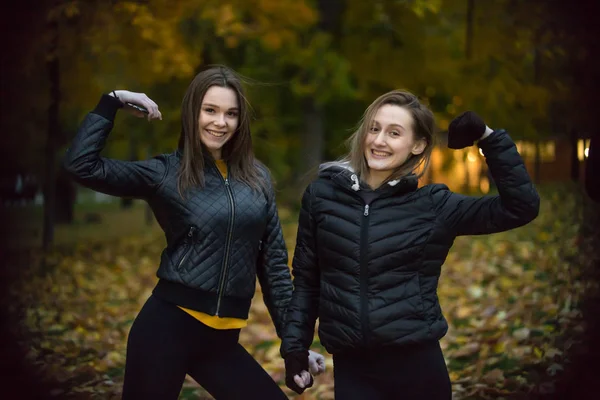 Porträtt av två tjejer i svarta jackor i höstens skog — Stockfoto