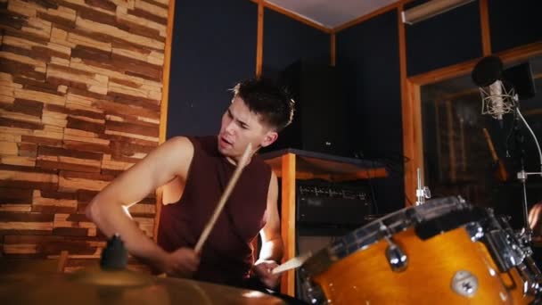 Hadnsome baterista activamente toca música en el estudio en un garaje. Movimiento lento — Vídeo de stock