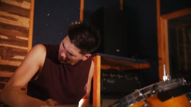 Hadnsome baterista com cabelo molhado ativamente toca música em estúdio em uma garagem. Movimento lento — Vídeo de Stock