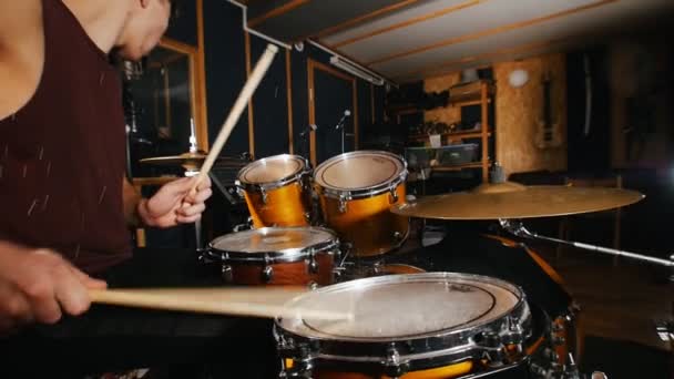 Барабанщик страстно играет музыку на мокрых барабанах в студии — стоковое видео