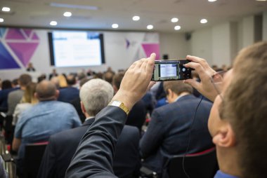 Arka iş toplantısında oturan insanlar. Bir adam bir telefon kaydı