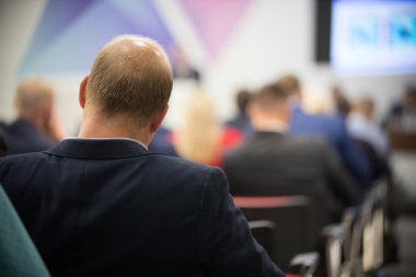 Arka iş toplantısında oturan insanlar. Kel adam arka