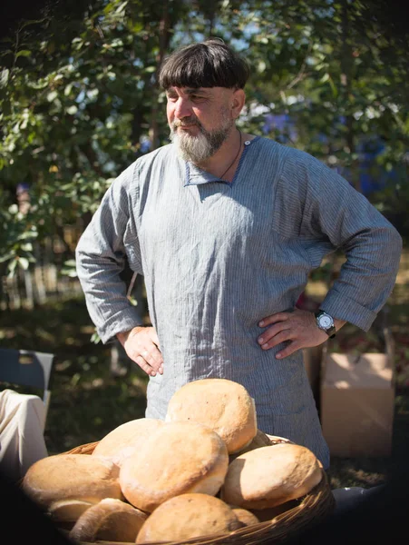 20 augustus 2018, Krasnovidovo, Rusland - kleding een man in traditionele Russisch verkopen brood — Stockfoto