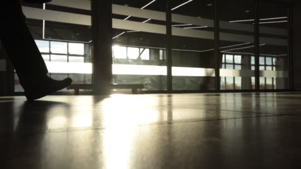 Achtergrondverlichting silhouet van mysterie man lopen voor grote raam. Close-up — Stockvideo