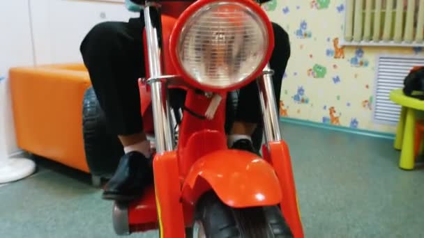 Barbería para niños. niño pequeño en motocicleta de juguete . — Vídeo de stock