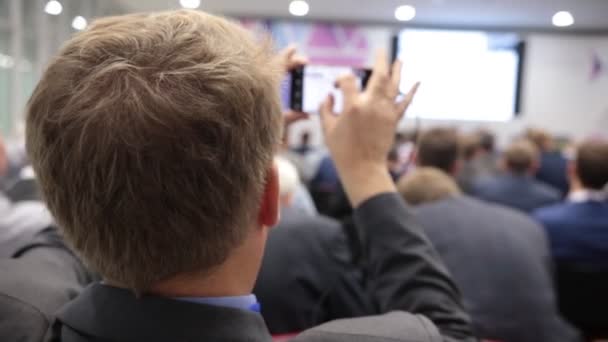 Jefes de gente en el auditorio. tomar fotos en el teléfono móvil — Vídeo de stock