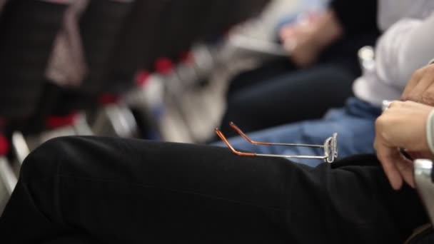 Manos de gente sosteniendo el teléfono móvil en el auditorio — Vídeos de Stock