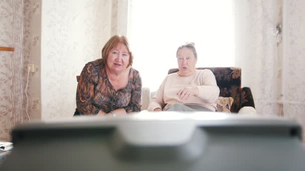 Las mujeres mayores se sentaron a relajarse y ver la televisión — Vídeo de stock